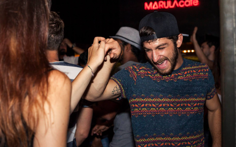 Barcelona es una ciudad que respira música por cada una de sus calles. Y cuando hablamos de ritmos latinos, nos referimos a una conexión profunda entre culturas, cuerpos que se mueven al compás de la historia, y sonidos que hacen bailar a la ciudad desde hace décadas. 

En Marula Café, llevamos años siendo testigos de esta evolución y de cómo la música latina, en todas sus formas, se ha integrado con naturalidad y pasión en el alma de la ciudad.
Barcelona se mueve al ritmo latino
Los ritmos latinos no son una moda, son una forma de vida. Y en Barcelona, esa vida se baila cada noche. La ciudad ha sido, durante años, un punto de encuentro para personas de todas partes del mundo. 
Muchas de ellas han traído consigo sonidos de su tierra: salsa, bachata, cumbia, reguetón, son cubano, merengue, y un sinfín de estilos que no han hecho más que enriquecer el panorama musical local.
El origen de los ritmos latinos: de América a Barcelona
Cuando hablamos de “ritmos latinos”, nos referimos a un conjunto de estilos musicales originados en América Latina y el Caribe. Son músicas con raíz africana, indígena y europea que han ido mezclándose durante siglos para dar lugar a una expresión cultural riquísima. 
Lo que tienen en común es su carácter festivo, su energía, y su capacidad de unir a la gente, sin importar el idioma, la edad o el origen.
Breve historia de la música latina en el mundo
La música latina se ha expandido por el mundo entero. Desde las orquestas de salsa en Nueva York hasta los sonidos urbanos que hoy dominan las listas globales. Cada generación ha encontrado una forma nueva de expresar emociones a través de estos ritmos. 
Y Barcelona, con su carácter abierto y su amor por la cultura, se ha convertido en un escenario ideal para que esta música siga evolucionando.
Cómo llegaron los ritmos latinos a Barcelona
La llegada de los ritmos latinos a Barcelona no se puede explicar en una sola línea: ha sido un proceso natural, impulsado por las personas migrantes, por quienes viajaron, por quienes exploraron. A partir de los años 80, la ciudad empezó a ver cómo la salsa y el merengue se colaban en las fiestas de barrio, en los bares, y en las salas. 
Luego llegó la bachata, más tarde el reguetón, y hoy en día, conviven todos los géneros, desde los clásicos hasta las nuevas propuestas de fusión.
La evolución de la música latina en la ciudad condal
Durante los años 80 y 90, los ritmos latinos vivieron un auge importante en Barcelona. Las primeras comunidades latinas empezaban a asentarse en la ciudad y con ellas llegaron los primeros locales donde bailar salsa o merengue. 
En aquellos tiempos, las pistas se llenaban con los clásicos de Héctor Lavoe, Celia Cruz o Juan Luis Guerra. La bachata, que antes era considerada música “de barrio”, empezó a ganar espacio y respeto.
La influencia del reguetón y la música urbana latina
En los 2000, el reguetón cambió las reglas del juego. Lo que empezó como un sonido underground en Puerto Rico, cruzó océanos y se instaló en los cascos de la gente joven en Barcelona. 
El reguetón abrió paso a nuevas voces, a un lenguaje directo, a letras que hablaban de fiesta, pero también de realidad. Y desde entonces, no ha parado de evolucionar, mezclándose con el trap, la electrónica y otros géneros globales.
La escena actual: mezcla de culturas y sonidos
Hoy en día, la música latina en Barcelona no es solo una escena… es una energía que se siente en muchos espacios. Ya no hay una única forma de sonar latino, porque se mezclan timbales con sintetizadores, trompetas con beats electrónicos. 
Se hace cumbia psicodélica, reguetón feminista, salsa con jazz. Y eso es lo que más nos emociona en Marula Café: ver cómo cada día la creatividad no tiene fronteras.
Los géneros latinos más populares en Barcelona
La ciudad tiene un amor especial por los ritmos que invitan a moverse. Algunos de los géneros latinos más populares que suenan cada semana en Marula Café (y en muchos otros rincones de la ciudad) son:
Salsa: nunca pasan de moda. Son los ritmos que muchas personas vienen a bailar, a aprender, a disfrutar desde el corazón.
Cumbia y merengue: perfectos para fiestas que no terminan hasta el amanecer. Energía pura.
Música urbana: son la banda sonora de toda una generación.
Fusión latina: desde flamenco con beats caribeños hasta hip hop con sabor tropical o el Latin Afro Jazz. La mezcla lo es todo.

Las mejores salas de conciertos latinos en Barcelona
En Marula Café siempre hemos apostado por la música en directo, por dar espacio a artistas locales, internacionales y emergentes. Aunque no nos gusta hablar de “mejores” en términos competitivos, sí queremos celebrar algunos espacios donde la música latina se vive con pasión:
Marula Café – Sí, aquí mismo. Somos un espacio abierto a todos los estilos musicales. Cada semana puedes encontrar desde una noche de funk hasta un live de cumbia, una sesión de DJ con afrobeat o un concierto de salsa dura. Lo importante es que la música sea real, auténtica y compartida con respeto.
Las salas más underground y alternativas – Barcelona está llena de rincones donde, si prestas atención, podrás escuchar una banda de son cubano o una sesión de reguetón old school con vinilos. La música latina vive también en espacios más pequeños, donde todo se siente más cercano.
Eventos y festivales latinos que no te puedes perder
Barcelona acoge cada año una gran variedad de eventos y festivales que celebran la diversidad musical de América Latina. Algunos de ellos son:
Festival de Salsa y Bachata de Barcelona – Uno de los encuentros más grandes del género en Europa, con talleres, conciertos y mucho baile.
Fiestas de reguetón y música urbana – Cada mes surgen nuevas propuestas para quienes disfrutan del perreo, el dembow o el trap.
Eventos al aire libre – En primavera y verano, los parques y plazas se llenan de conciertos gratuitos, DJs y colectivos que celebran la música latina con toda la comunidad.
¿Dónde aprender a bailar ritmos latinos en Barcelona?
El baile es parte esencial de la cultura latina. En Barcelona hay muchísimas escuelas y espacios inclusivos donde podés aprender desde cero o mejorar tus pasos. Algunos colectivos también ofrecen clases abiertas en espacios públicos. Lo más importante es perder la vergüenza, dejarse llevar por la música y conectar con otres.
También te dejamos con un artículo en el que te explicamos cuáles son los mejores espacios para bailar música funk en Barcelona.
Barcelona, capital latina del Mediterráneo
Lo que hace especial a Barcelona no es solo su arquitectura o sus playas. Es la gente, la mezcla, la libertad con la que se viven las culturas. Y la música latina forma parte esencial de esa identidad. En Marula Café, nos sentimos afortunadas de ser parte de esa historia, de abrir nuestras puertas a todos los géneros, a todas las personas y a todas las formas de disfrutar la música.
ritmos latinos en Barcelona2